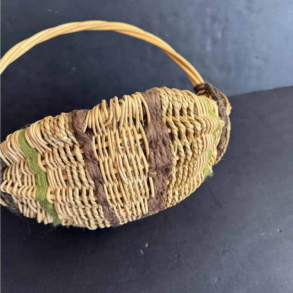 Vintage handwoven basket with brown and green yarn details and eye of God.